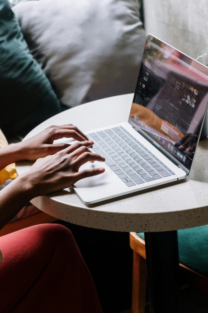 A businesswoman types on a laptop while working at a cafe table, capturing a modern freelance work lifestyle.